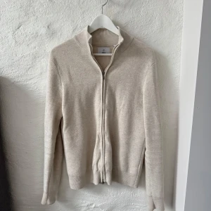 Zip Cardigan Bläck - Säljer en beige Zip Cardigan från Bläck i storlek S. Tröjan är köpt på MQ för 900 kr och är i väldigt fint skick.