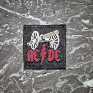 AC/DC tygmärke! - Ett litet tygmärke med AC/DC! Baksidan är som på bild 2 tydligt använd, men går absolut att sy på ändå! Kolla gärna in min sida för eventuella bundles :) Tygmärket passar trots sitt skick perfekt på din battlevest eller skinnjacka! 🌟😎