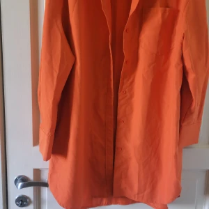 Orange skjorta från SHEIN - Säljer en orange skjorta från SHEIN i storlek L. Skjortan har klassisk krage, lång ärm och knäppning framtill. Perfekt för dig som vill ha en färgstark och enkel skjorta i garderoben.