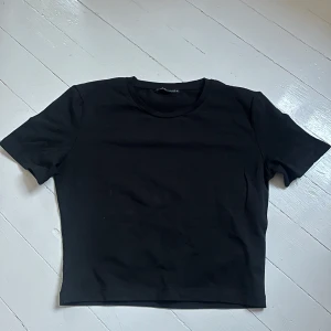 Svart basic t-shirt från Zara - En enkel svart t-shirt med rund hals och korta ärmar från Zara. Perfekt att matcha med jeans eller kjol för en clean look. T-shirten har en rak passform och är tillverkad i mjukt material. Knappt använd. Skriv för fler bilder💞