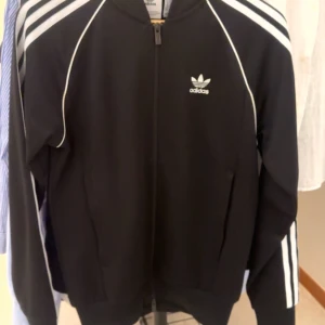 Svart Adidas track jacket med vita ränder - Aldrig använd storlek XS 