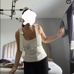 Zara topp - Snygg vit linnetopp med breda axelband som knyts i rosetter på axlarna. 