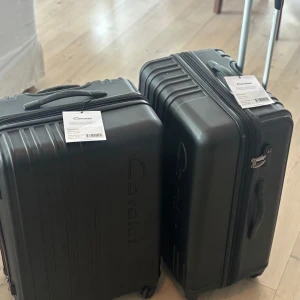 Svart resväska Cavalet Malibu 1200 kr st - Säljer en svart resväska från Cavalet, modell Malibu. Väskan har hårt skal, fyra hjul och dragkedja med TSA-lås. Perfekt för resor med smidig hantering tack vare teleskophandtag och robust design. En för 1200kr två för 2300 kr helt nya och oanvända inte ens öppnade 