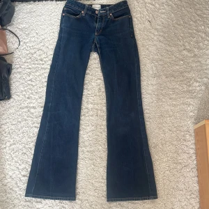 Mörkblå lågmidjade jeans från Abrand Jeans - Mörkblå lågmidjade jeans från Abrand Jeans med klassisk femficksdesign och bootcut passform. Jeansen har kontrastsömmar och en enkel, stilren look som passar till många olika outfits.