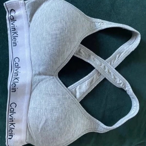 Grå bralette från Calvin Klein - jättesnygg bralette i storlek xs, endast använd max 2 gånger eftersom den är för liten. Orginalpris runt  499kr säljer för 300. Jättebra skick så gott som ny! Har en likadan i svart.