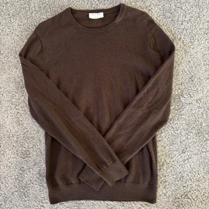 Brun stickadtröja från Tiger of Sweden - Säljer en stilren brun tröja från Tiger of Sweden. Tröjan har rund halsringning och långa ärmar, perfekt för lager-på-lager. Enkel och klassisk design som passar till mycket. Plagget har inga tecken på användning. Hör av dig vid frågor! 