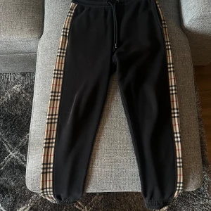 Svarta mjukisbyxor från Burberry - Svarta mjukisbyxor från Burberry. Byxorna har resår och snörning i midjan samt muddar vid bensluten. Byxorna är aningen blekta annars i felfritt skick. Inköpta från NK Göteborg. Ska nog kunna leta fram kvittot om så önskas.