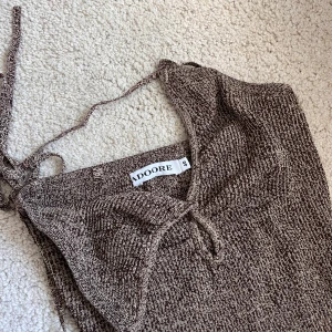 Adoore brun klänning - Helt oanvänd klänning från Adoore, strlk 40 men passar på mig som är en 38a. Köpt för ca 1år sedan, men säljer för har ej använt den.