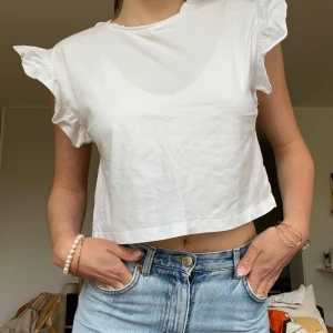 Vit croppad topp med volangärmar från Zara - Säljer en vit croppad topp från Zara med volangdetaljer, i mycket fint skick :)