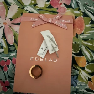 Smyckeset från Edblad - Säljer ett smyckeset från Edblad med ett par glittriga korsörhängen i silverfärg och en stilren ring i guldton⭐️