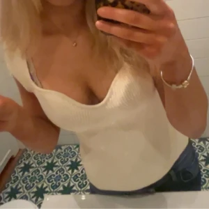 Vit ribbad topp med sweetheart-urringning - Säljer en vit ribbad topp med korta ärmar och snygg sweetheart-urringning. 