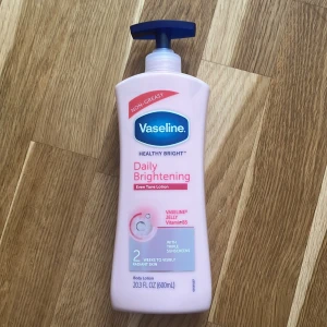 Vaseline Daily Brightening Body Lotion - Vaseline Healthy Bright Daily Brightening body lotion med Vitamin B3 och solskydd. Stor pumpflaska på 600 ml i ljusrosa plast. ÖPPNAD MEN OANVÄND
