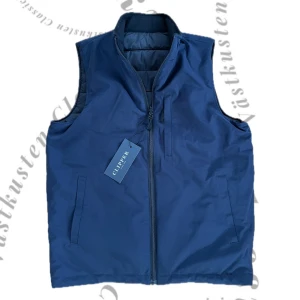 Väst - Snygg mörkblå/svart reversibel väst. Perfekt för lager-på-lager under kyliga dagar samt nu till våren. Västen har en stilren design, där du själv kan välja ifall den ska vara mörkblå eller svart utvändigt. Västen är helt ny med prislapp. Inga defekter överhuvudtaget. 