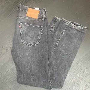 Levis 501🍾 - Nästan aldrig användt!!! Klassiska mörkgrå Levis 501 jeans med rak passform och femficksdesign. Byxorna har knappgylf och tydlig Levis-lapp bak i midjan. Snyggt tvättad mörkgrå färg.