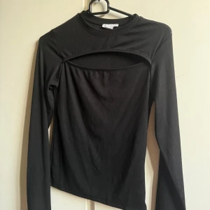 Ribbad topp  - Svart ribbad topp med cut-out detalj över bröstet.