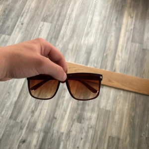 Bruna fyrkantiga solglasögon liknar rayban boyfriend  - Snygga solglasögon med fyrkantiga bågar i brun plast. Glasen är tonade och ger en cool retrovibe. Perfekta för dig som vill sticka ut med en stilren accessoar.