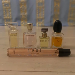 Fem små parfymer från olika märken - Säljer ett set med fem olika parfymer: Eternity Moment och Eternity från Calvin Klein, Miracle och Idôle från Lancôme, samt Sì från Giorgio Armani. Flaskorna är små och perfekta för resor eller att prova nya dofter. Idôle-flaskan är avlång och elegant med svart kork.