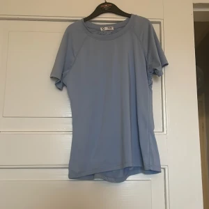 Ljusblå sportig träningskjorta från Cubus - Ljusblå t-shirt med sportig känsla från Cubus. T-shirten har korta ärmar och meshpanel på ryggen för extra ventilation. Perfekt för träning eller aktiva dagar. Enkel och stilren design.