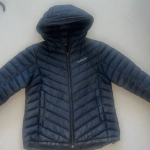 Svart dunjacka med huva från Peak Performance - Säljer en svart dunjacka från Peak Performance i storlek M. Ord pris 2990 Jackan har huva, dragkedja och ett stilrent, quiltat mönster. Perfekt för kyliga dagar och enkel att matcha med olika outfits.