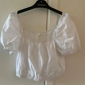 Vit croppad blus med puffärmar - Säljer en vit croppad blus med puffiga korta ärmar. Superfin till sommaren!! 