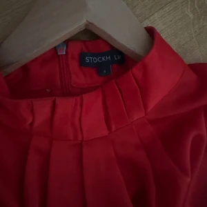Röd halterneck blus från STOCKH LM - Säljer en röd halterneck blus från STOCKH LM i storlek S. Jag skulle säga att den är lite större i storleken så den passar S-M