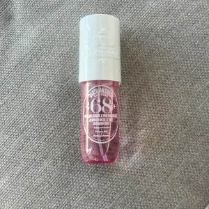 Sol de Janeiro Cheirosa 68 Perfume Mist - En fräsch och tropisk parfymmist från Sol de Janeiro med doftnoter av pink dragonfruit, litchi, brasiliansk jasmin, havsbris, hibiskus, vanilj och solig mysk. Flaskan är rosa med vitt lock och rymmer 90 ml. Oöppnad och oanvänd. Har plasten kvar 