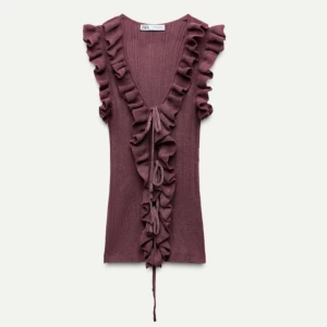 Stickad topp med volanger och knytningar  - Supersöt vinröd topp från Zara med volanger och knytningar. Använd ett fåtal gånger, kommer därmed i bra skick o har inga defekter. Skriv för fler bilder! Säljer då den inte kommer till användning längre.