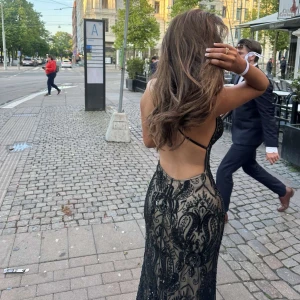 Svart långklänning med paljetter och öppen rygg - Säljer av denna underbara bal klänning, den kommer ju inte till nån mer användning för mig och har gjort sitt. Använd 1 gång köpt ny, fint skick och handgjord, den är tung i materialet och har lite släp. Beige silke inuti utpå är det svarta paljetter. 163cm lång vikt 52 bär xs och s i st. För att förtydliga så är denna handgjort och finns inte många exemplar av just detta mönster och är tung i matrialet därav priset. 