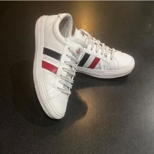 «Moncler skor» - Snygga vita sneakers från Moncler. Skorna är i väldigt bra skick och det finns inte några stora defekter. Skorna är i storlek 41 men passar 42.     Skick: 8,5/10   Nypris: ca 6000kr