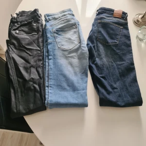Tre par jeans i olika tvättar - Säljer tre par jeans i olika färger: ett par svarta, ett par ljusblå och ett par mörkblå. Klassisk femficksmodell med dragkedja och knapp. Perfekta för dig som vill ha variation i garderoben.