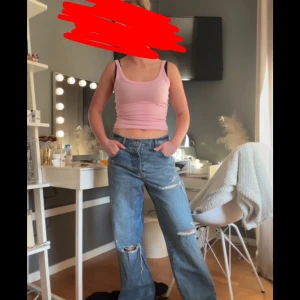 Blå jeans från Zara model lose fite  - Säljer ett par blå jeans som är lose fite och slitna detaljer vid knäna och fickorna. Jeansen är mide rise i midjan och klassisk femficksdesign. Perfekta för en avslappnad och trendig look. Just nu är dessa jeans så trendiga 