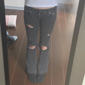 Grå slitna jeans med hål - Säljer ett par grå jeans med flera slitningar och hål på benen. Byxorna har normal passform och klassisk femficksdesign. Hål mellan benen därav priset, men går säkert att sy.