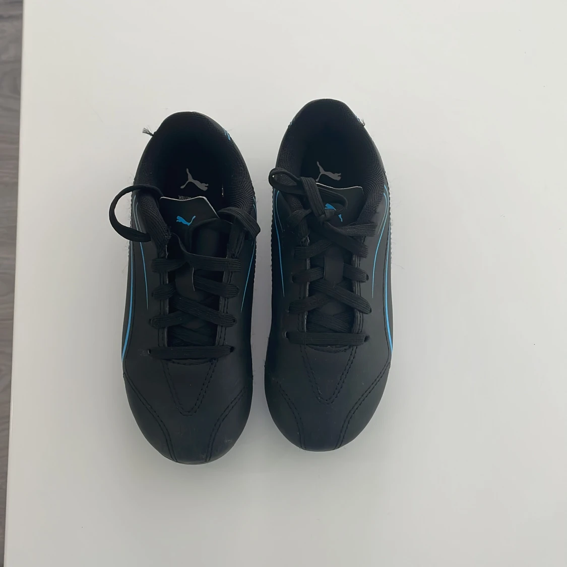 Svarta fotbollsskor från Puma med blå detaljer