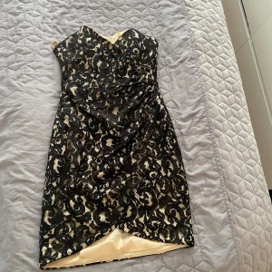 Svart och champagnefärgad spetsklänning med pärldetaljer - Säljer en snygg axelbandslös klänning i svart spets med champagnefärgad underklänning. Klänningen har snörning i ryggen och pärldetaljer upptill. Figurnära passform och omlott nedtill. Perfekt för dig som vill sticka ut!hämtas i norsborg botkyrka eller fraktas så fort så möjligt pågrund av flytt. Har 30 andra fina festklänningar skicka pm tack passar 36-38.