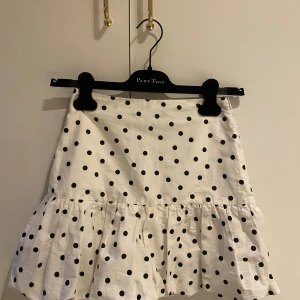 Vit prickig kjol från Pull&Bear - Supersöt vit kjol med svarta prickar från Pull&Bear. Pris kan diskuteras🩷