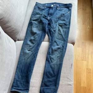 Levi's 520 jeans blå W32 L32 - Säljer ett par klassiska blå Levi's 520 jeans med normal passform och raka ben. Jeansen har fem fickor, dragkedja och knapp i midjan samt tydliga Levi's-detaljer som läderpatch och röda etiketten bak.