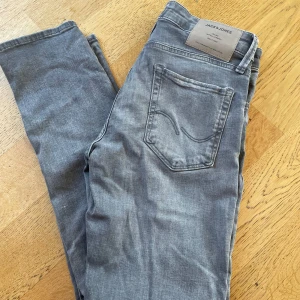 Grå jeans från Jack & Jones - Snygga grå jeans från Jack & Jones i en slim fit passform. Modellen är Glenn. Inga defekter och inte särskilt använda. Perfekta för en stilren look. Frågor? Skriv!