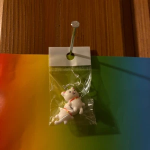 Söta björnörhängen med röd detalj - Ett par örhängen med vita björnar som har små röda detaljer runt halsen. Hängsmyckena är lekfulla och passar perfekt för dig som gillar gulliga accessoarer.