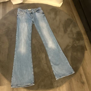 Ljusblå bootcut jeans från ONLY - Säljer ett par ljusblå jeans från ONLY med bootcut-passform. Jeansen är lågmidjade och är jätte fina. Säljer pågrund av att jag köpt fel storlek så jeansen är som nya använda en gång.