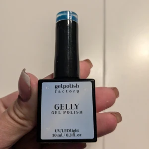 Blått glitter gel nagellack från Gelpolish Factory - Säljer ett gel nagellack från Gelpolish Factory i färgen blått med glitter. Flaskan innehåller 10 ml och används med UV/LED-lampa. Perfekt för att skapa glittriga och snygga naglar.