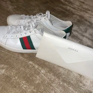 ÄKTA gucci skor med kvitto  - Säljer ett par klassiska vita ÄKTA Gucci sneakers  med kvitto. Priset kan diskuteras. OBS skorna är stora i storleken !