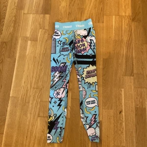 Färgglada leggings från Stronger med serietidningsmönster - Säljer ett par super sköna och fina  leggings från Stronger i storlek XS. 