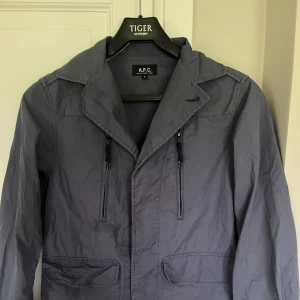 A.P.C. Overshirt - Säljer en fet blå overshirt från A.P.C. med klassisk krage och dragkedjor på bröstet. Materialet är tunnt och passar därför perfekt nu till sommaren! 
