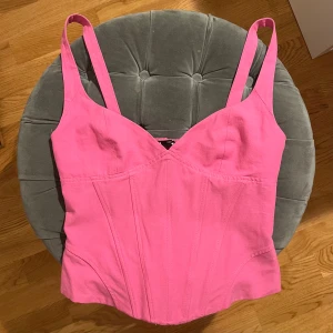 Rosa korsettopp - Säljer en snygg rosa korsettopp med breda axelband. Använt en gång. Har sytt in den på baksidan för att den ska sitta bättre men det är jätteenkelt och sprätta upp den! Passar xs och s. Kom privat vid frågor 💖💖💖
