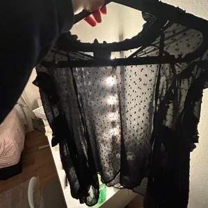 Svart  genomskinlig blus med detaljer  - Detaljer på ärmarna 