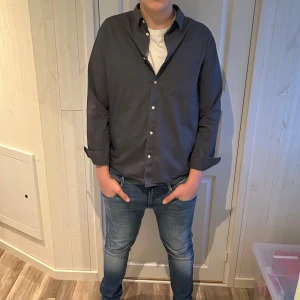 Mörkblå skjorta från H&M - Tja, Säljer en stilren mörkblå skjorta från H&M i storlek L. Skjortan har långa ärmar och knappar framtill. Perfekt för en avslappnad men ändå uppklädd look. Tvättar och stryker innan köp! Tveka inte på att höra av er vid funderingar🥂