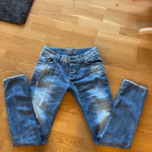 Blå jeans från Dolce & Gabbana - Snygga blå jeans från Dolce & Gabbana med en sliten look och ljusa tvättade detaljer. De har en klassisk femficksdesign och knappgylf. Perfekta för en avslappnad stil.