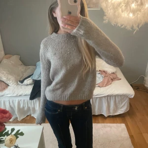 Beige stickad tröja från Zara - Säljer en snygg beige stickad tröja från Zara med pärldetaljer vid halsen. Tröjan har långa ärmar och en croppad passform som ger en modern look. Perfekt för kyligare dagar och använt 1 gång!!💕
