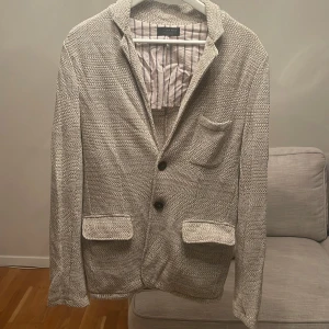 Beige kavaj från Zara Man - Snygg beige kavaj från Zara Man i storlek M. Tillverkad i Italien med ett stilrent mönster och två knappar framtill. Perfekt för en elegant look.