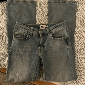 Blå jeans från 157 - Snygga blå jeans från 157 med en klassisk femficksdesign. De har en låg midja och bootcut-stil som ger en avslappnad look. Perfekta för en casual outfit. Passar nog bra på någon som är 160-165 typ. Är använda en gång och är precis som nya, så väldigt bra skick!
